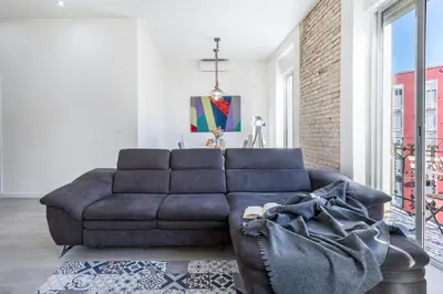 a blue couch in a living room with a brick wall at Travel Habitat Ruzafa Apartment in Valencia