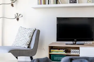 a living room with a tv and a chair at Travel Habitat Ruzafa Apartment in Valencia