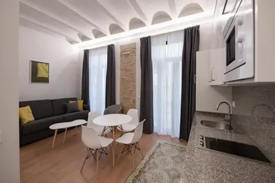a kitchen and living room with a table and chairs at Old Town Flats Casa Burguerini in Valencia