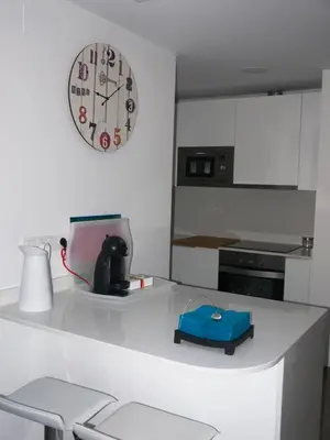 a white kitchen with a clock on the wall at MARIETA in Valencia