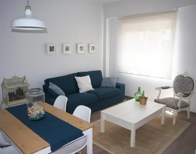a living room with a blue couch and a table at MARIETA in Valencia