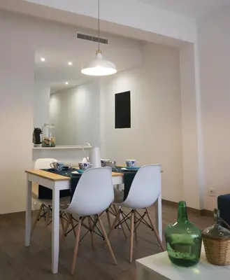 a dining room with a table and white chairs at MARIETA in Valencia