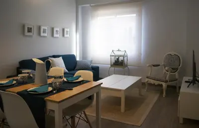 a living room with a blue couch and a table at MARIETA in Valencia