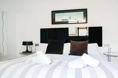 a bedroom with a white bed with a tv on the wall at Happy Apartments Valencia in Valencia
