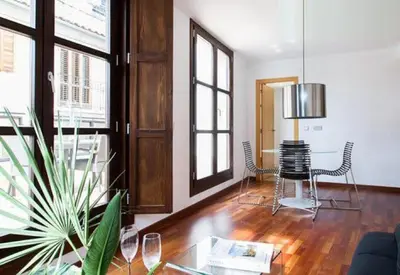 a living room with a table and chairs and windows at Happy Apartments Valencia in Valencia