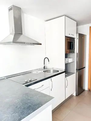 a white kitchen with a sink and a refrigerator at Happy Apartments Valencia in Valencia