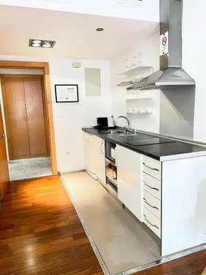 a kitchen with white cabinets and a black counter top at Happy Apartments Valencia in Valencia