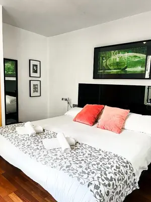 a bedroom with a large white bed with red pillows at Happy Apartments Valencia in Valencia