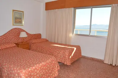 a hotel room with two beds and a window at Apartamentos Florazar II Ajhory in Cullera