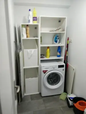 a laundry room with a washing machine and shelves at Apartamento cerca de la playa y Ciudad de las Ciencias in Valencia
