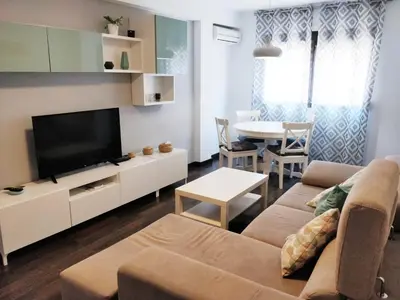 a living room with a couch and a tv and a table at Apartamento cerca de la playa y Ciudad de las Ciencias in Valencia