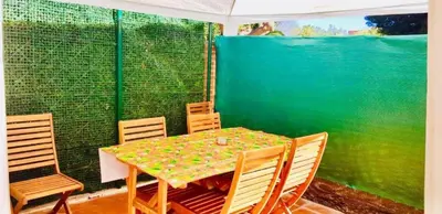 a table and chairs on a balcony with a green wall at APARTAMENTO CERCA DE PLAYA Y MONTAÑA IDEAL FAMILIAS O RELAX in Puzol