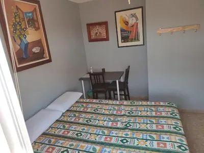 a bedroom with a bed and a table with a chair at Casa Serra - PATERNA - APARTAMENTO ALQUILA 3 HABITACIONES CON GARAJE in Paterna