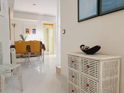 a living room with a table and chairs and a white cabinet at Penthouse Inlakesh in Valencia