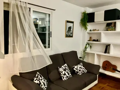 a living room with a couch and a window at Rio Turia Skatehouse in Valencia