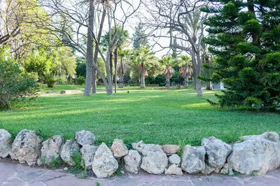 a pile of rocks in a park with trees and grass at Villa Entrenaranjos in Picassent