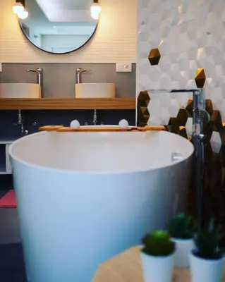 a bathroom with a tub and a sink and a mirror at Hexagonal Design Apartment in Valencia