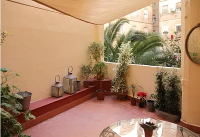 a courtyard with potted plants and a glass table at 7 Moons B&B in Valencia