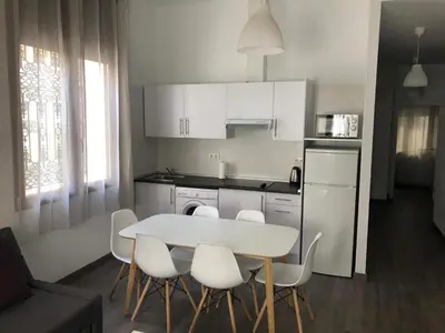 a kitchen with a white table and white chairs at Zerka Sendra in Valencia