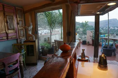 a living room with a table and a large window at CASA DEL ARTE casa rural in Chulilla