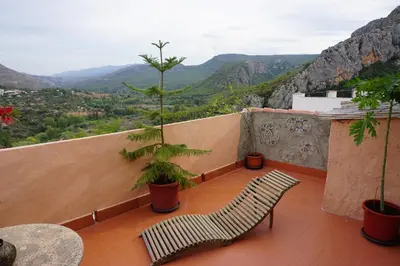 a balcony with two chairs and a view of mountains at CASA DEL ARTE casa rural in Chulilla