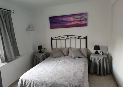 a bedroom with a bed and two tables with lamps at Casa Centro Jérica in Jérica