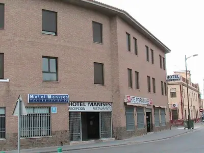 a large brick building on the corner of a street at Hotel Manises in Manises