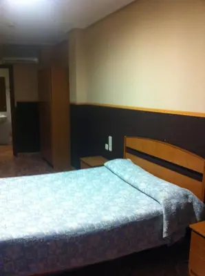 a bedroom with a bed with a blue blanket on it at Hotel Manises in Manises