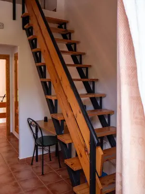 a staircase in a house with a table and a chair at El Cerrao-PauNatura in Sot de Chera
