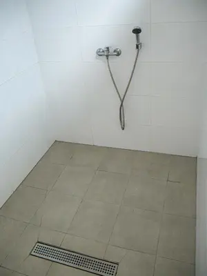 a shower stall with a hose on a tiled floor at El Cerrao-PauNatura in Sot de Chera