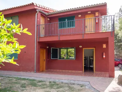 a red house with a balcony on top of it at El Cerrao-PauNatura in Sot de Chera