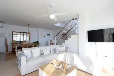 a living room with a white couch and a table at Can Lou-Casa con Caracter en Cullera in Faro de Cullera