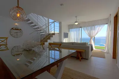 a living room with a staircase and a couch and a clock at Can Lou-Casa con Caracter en Cullera in Faro de Cullera