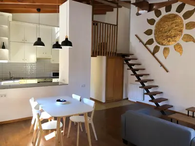 a kitchen and dining room with a table and a spiral staircase at Cozy en Blanch. Center in Valencia