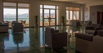 a lobby with chairs and tables in a building at Hotel Sicania in Cullera