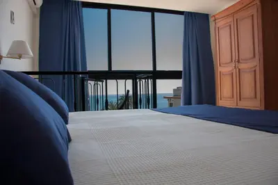 a bedroom with a bed with a view of the ocean at Hotel Sicania in Cullera