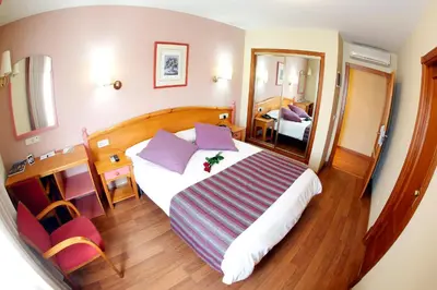a hotel room with a large bed and a mirror at Maria de Luna in Segorbe