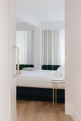 a bedroom with a bed and a chair at Room Mate Cosmo - City Centre, Valencia in Valencia