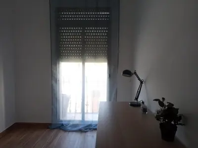 a room with a table and a window with a lamp at Sofia's Flat in Valencia