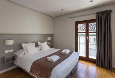 a bedroom with a large bed with two towels on it at Mon Suites Catedral in Valencia