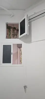 a white kitchen with a tv and a window at Habitacion en casa de familia 