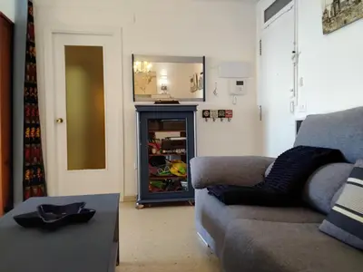 a living room with a couch and a refrigerator at IDEALLY located on BEACH in Port Saplaya