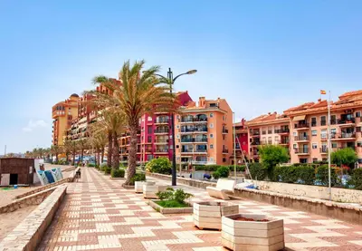 a city street with palm trees and buildings at IDEALLY located on BEACH in Port Saplaya