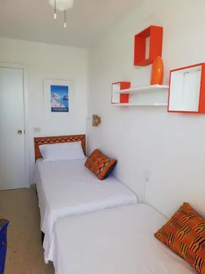 two beds in a room with white walls at IDEALLY located on BEACH in Port Saplaya