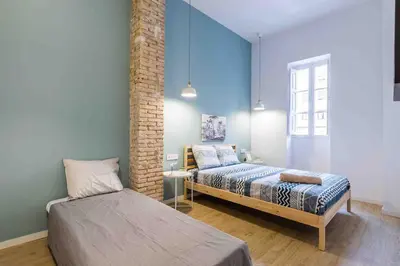 a bedroom with two beds and a brick wall at Cozy apartment Valencia city center! in Valencia