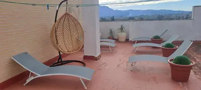 a patio with chairs and potted plants on a balcony at Apartamento Romero Valencia in Benicull
