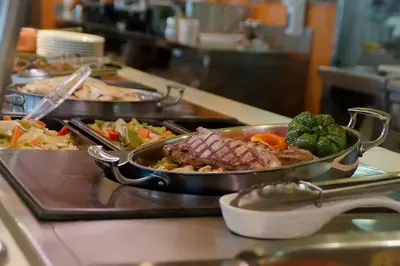 a buffet with several dishes of food on a counter at Hotel AS Torrent in Torrent