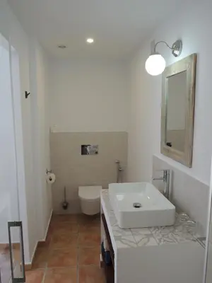 a white bathroom with a sink and a toilet at Finca Mirador in Macastre
