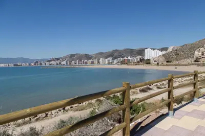 a view of a beach with a wooden fence at Los Olivos Apartment Cullera in Cullera