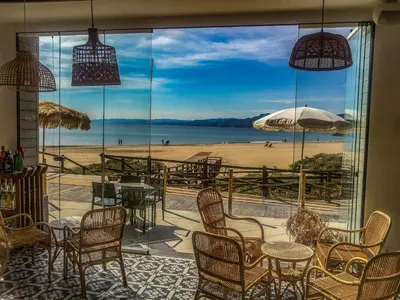 a patio with tables and chairs and a view of the beach at Los Olivos Apartment Cullera in Cullera